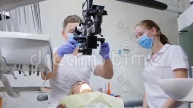 <strong>医务</strong>所、医生和护士用双眼显微镜对躺卧病人进行口腔手术
